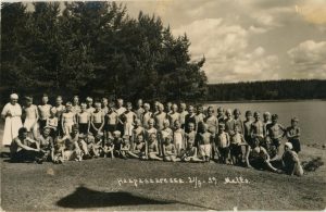 Haapasaaren leirimuistoista kuva, hiekkakentällä iso joukko lapsia ja nuoria rivissä.